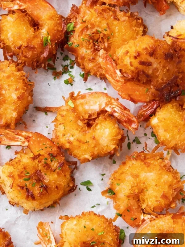 Crispy Panko Shrimp Tacos with Tangy Slaw 10 Coconut shrimp fried crispy golden on parchment paper.