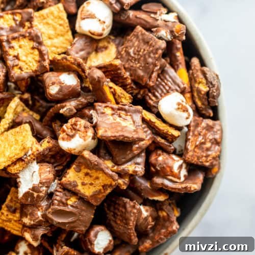 Overhead shot of snack mix in a bowl on a white counter.