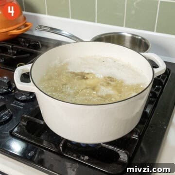 Garlic Parmesan Mashed Potatoes Recipe — Creamy Comfort Side Dish 7 Boiling potatoes in a pot of water.