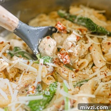scooping a spoon of marry me chicken pasta.
