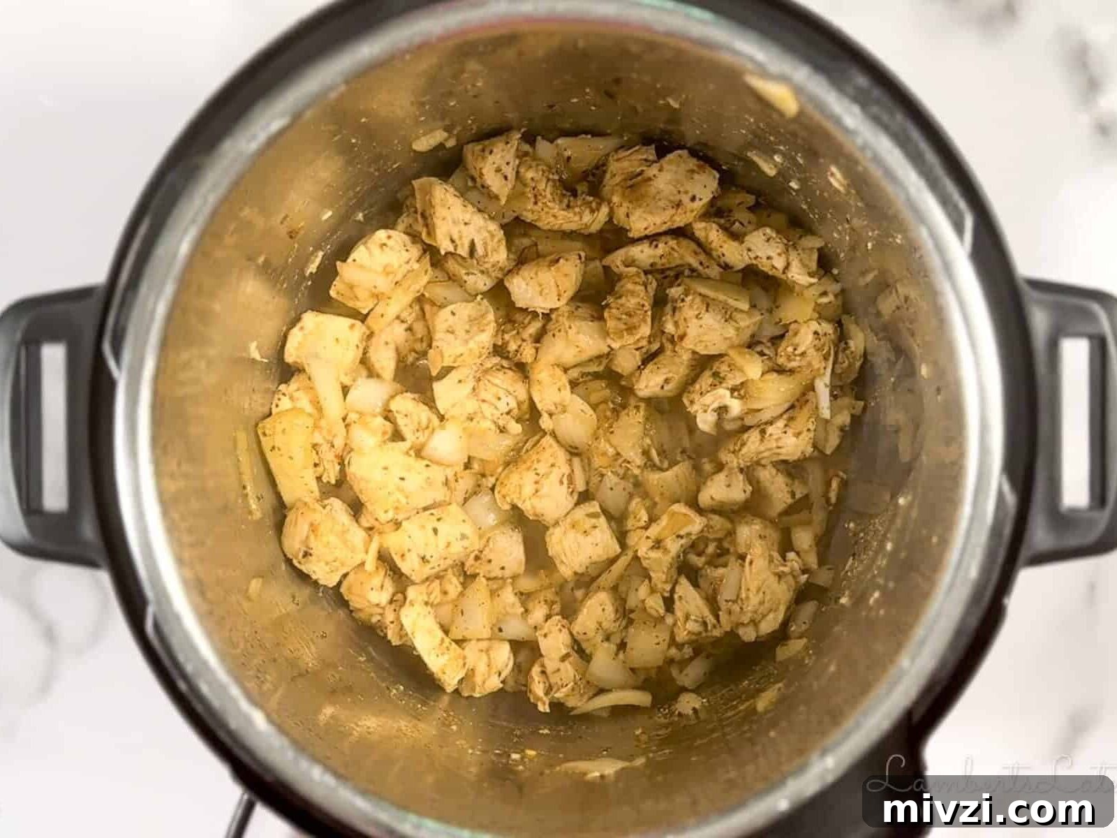 chicken, onion, and garlic cooking in an instant pot.