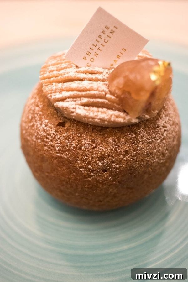 a chestnut pastry puff topped with a chestnut on an aqua plate