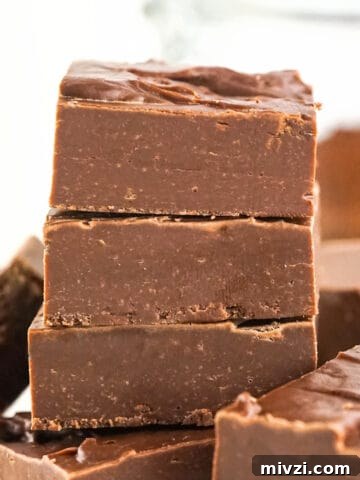 Chocolate fudge squares in a stack with a white background.