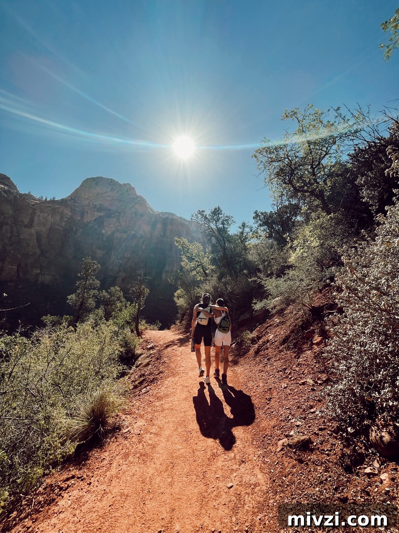 two girls with their arms around their back walking into the sun orb