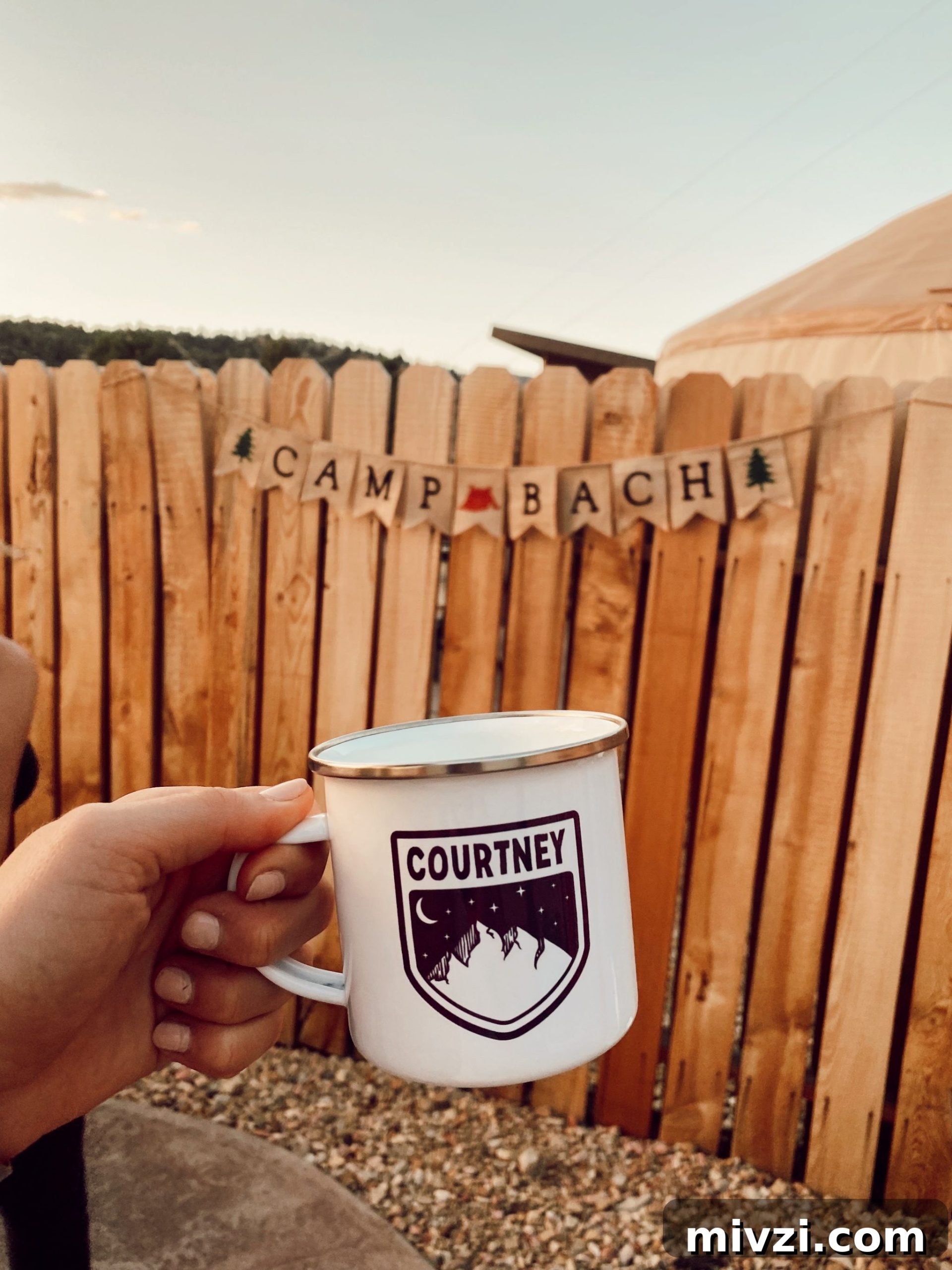 campfire mug that says courtney with wooden fence behind it