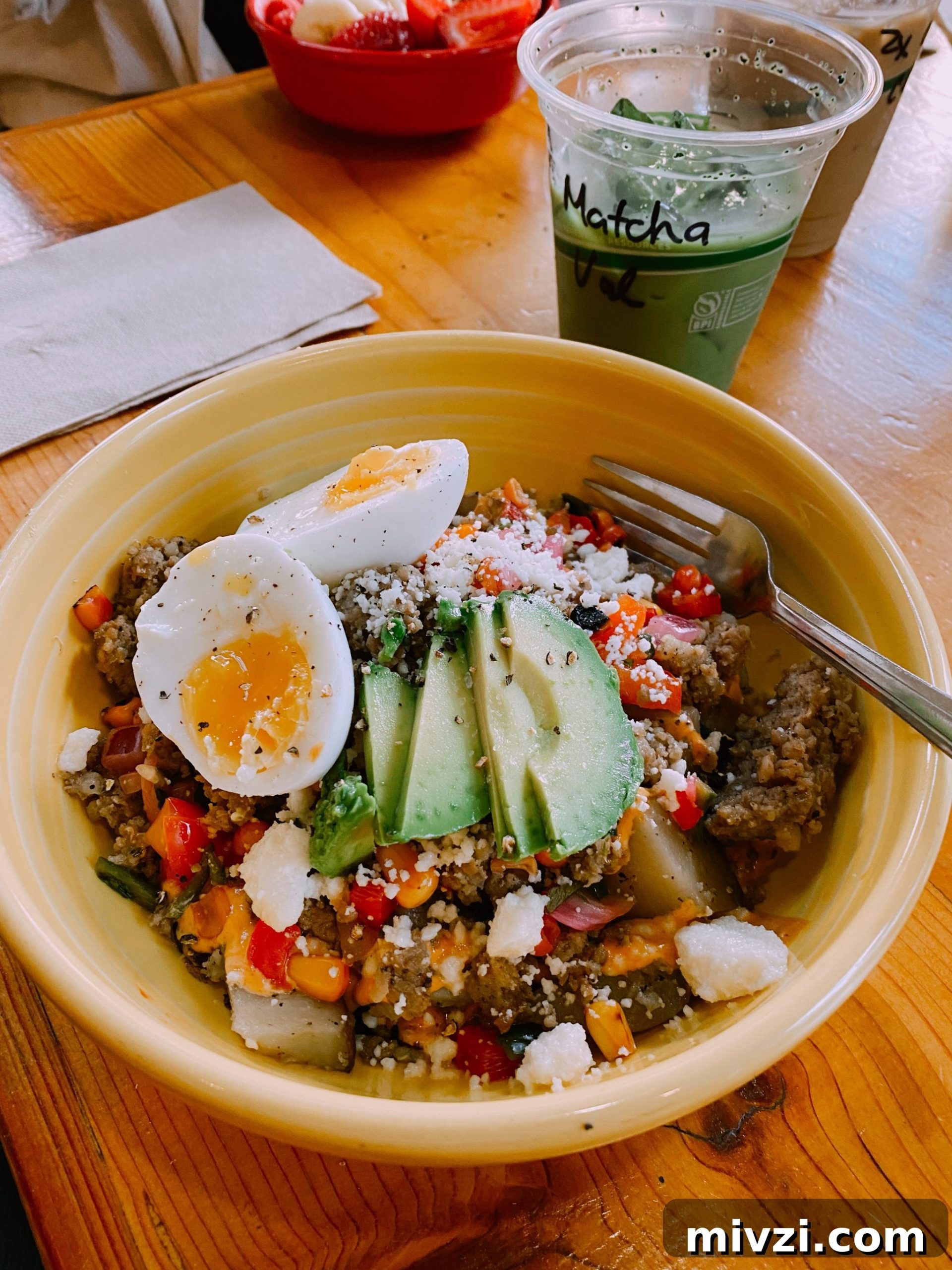 yellow bowl with quinoa, avocado, and eggs
