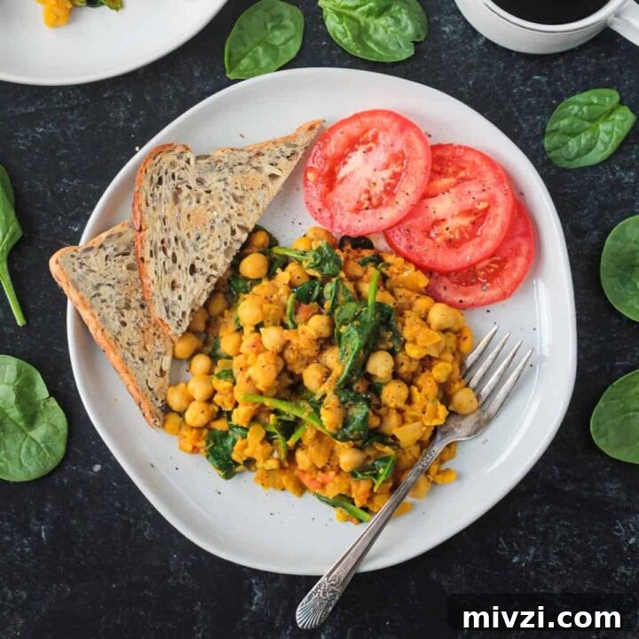 Two plates of chickpea scramble next to a cup of coffee and plate of toast.