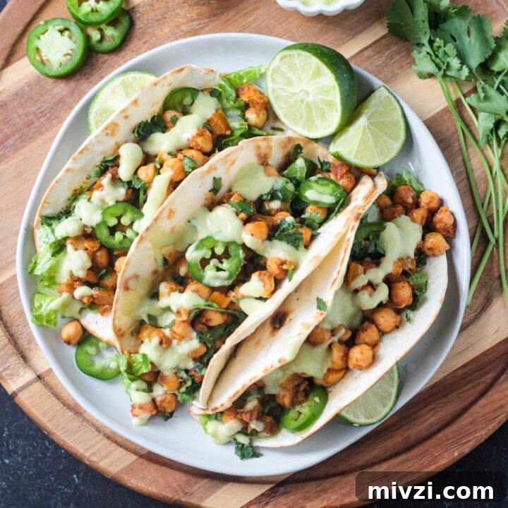 Three vegan chickpea tacos on a dinner plate.