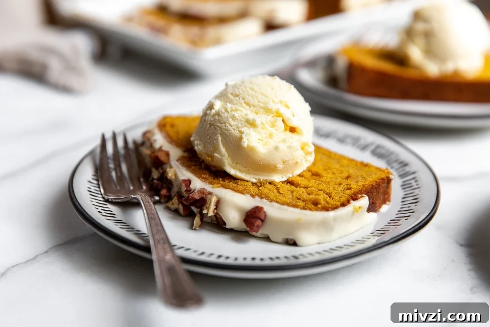 Pumpkin Pound Cake with Bourbon Cream Cheese Frosting рецепт 9 A slice of cake on a plate with a scoop of vanilla ice cream on top.