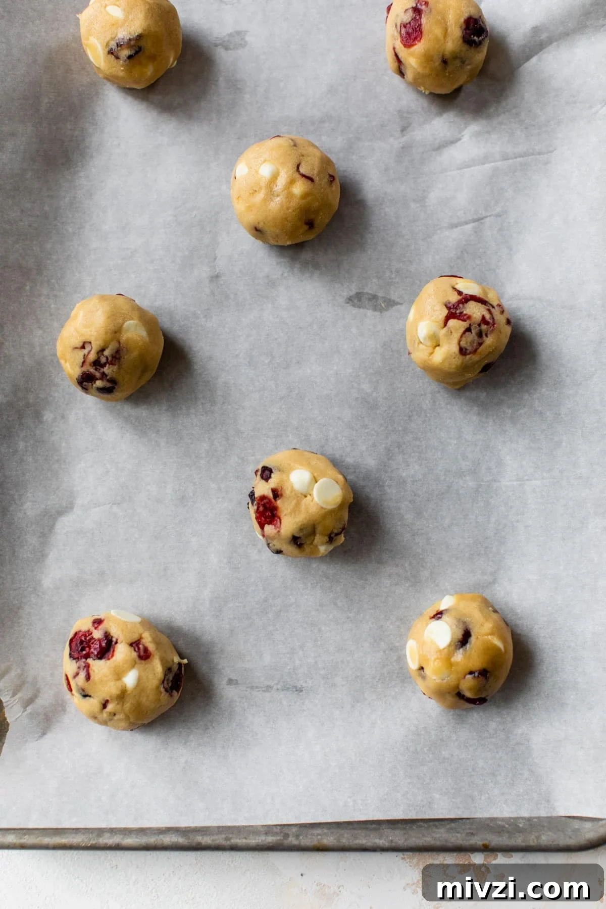 cookie dough balls on a parchment lined baking sheet