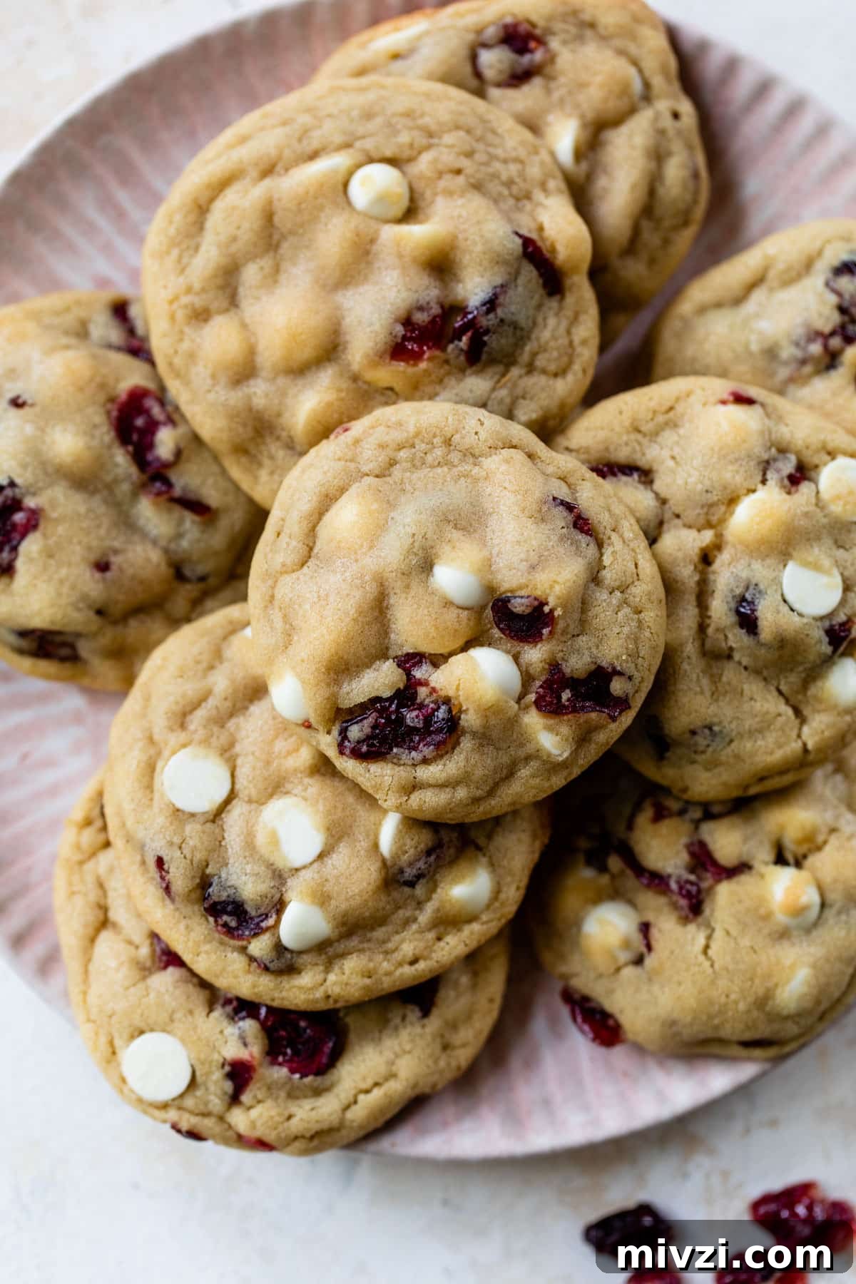cranberry white chocolate cookies stacked on top of each other on a plate