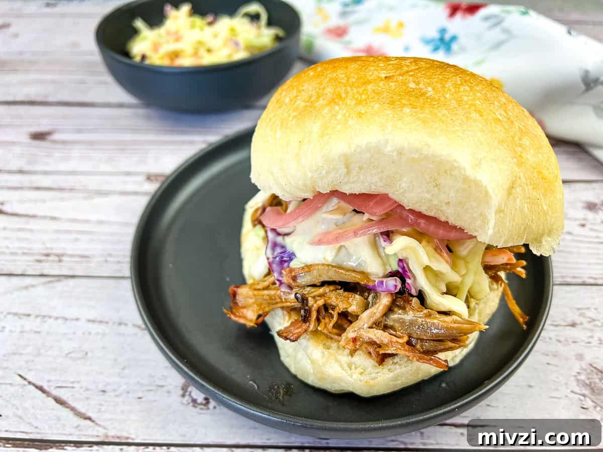 37 Winter Olympics Dishes to Warm Cold Nights and Long Broadcasts 20 Pulled Pork Sandwich with Coleslaw on a black plate.