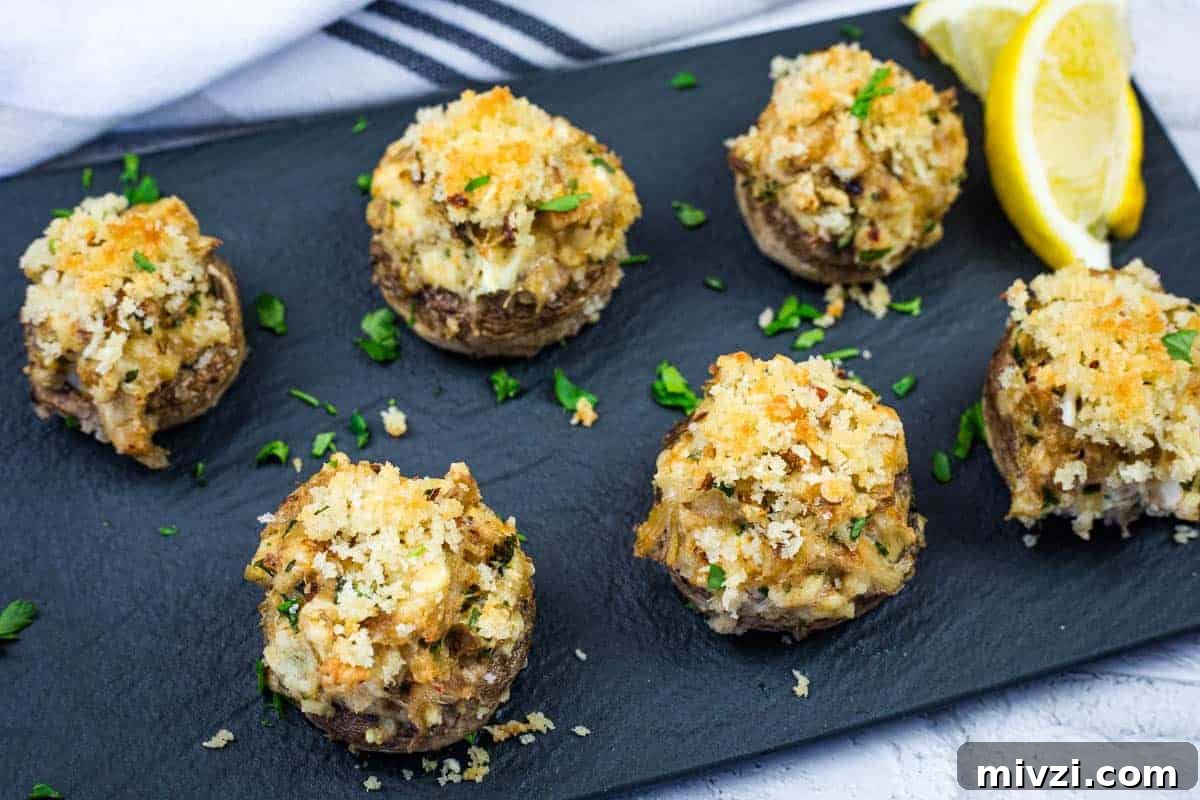 37 Winter Olympics Dishes to Warm Cold Nights and Long Broadcasts 3 A slate platter with six crab stuffed mushrooms garnished with herbs.