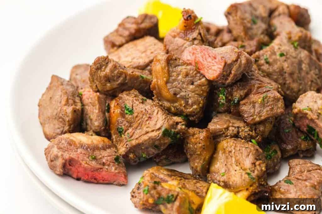 37 Winter Olympics Dishes to Warm Cold Nights and Long Broadcasts 4 A plate of cooked steak bites garnished with herbs, served with pieces of yellow bell pepper.