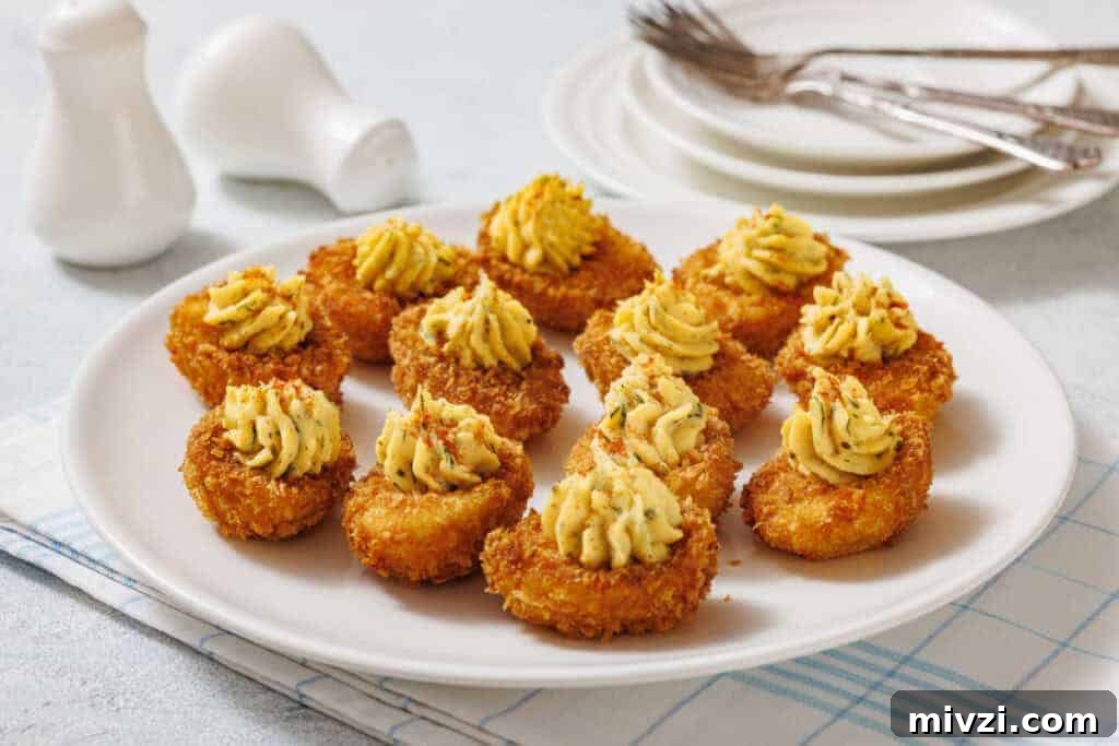 37 Winter Olympics Dishes to Warm Cold Nights and Long Broadcasts 6 A white plate with fried deviled eggs, garnished with herbs, is shown with salt and pepper shakers, plates, forks, and a cloth in the background.