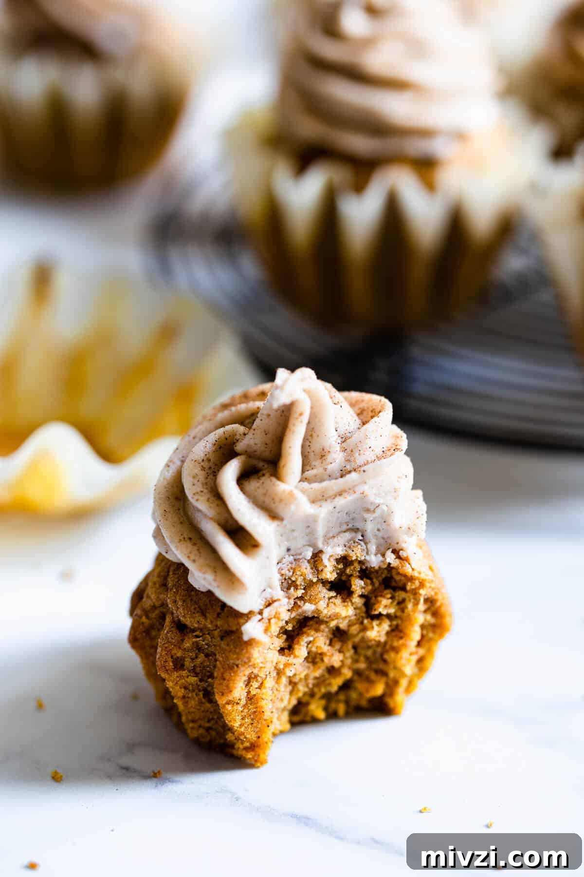 close up of a pumpkin cupcake with bite taken out of it