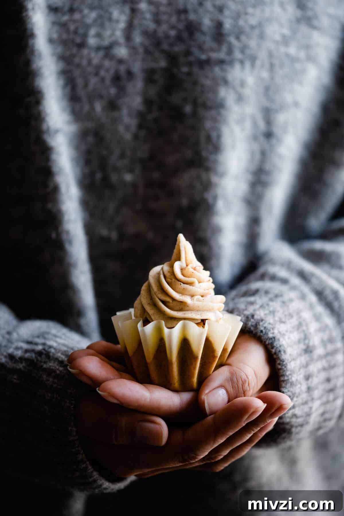 straight ahead shot of a person holding a cupcake in their hands