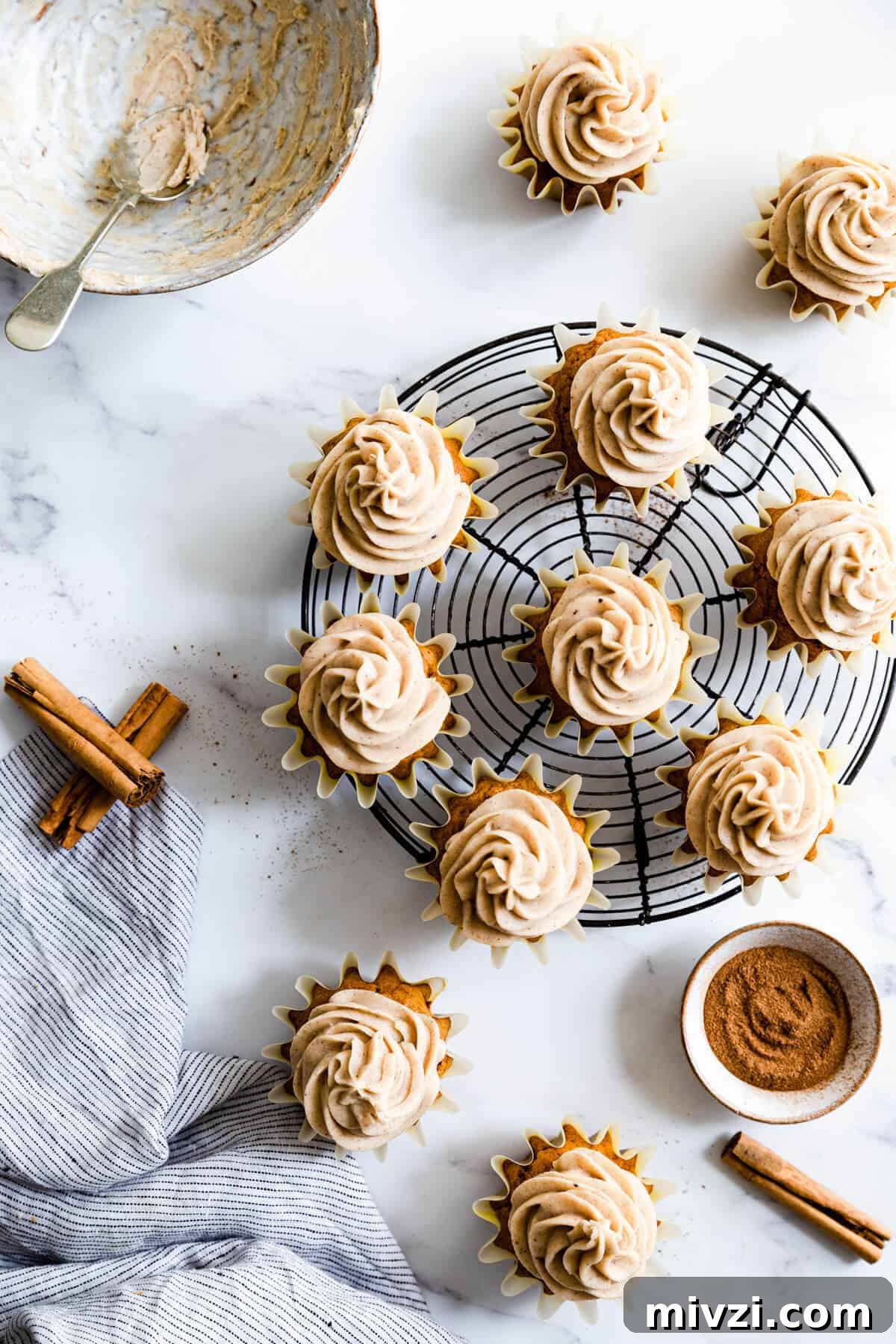Pumpkin and chai cupcakes arranged on a round cooling rack