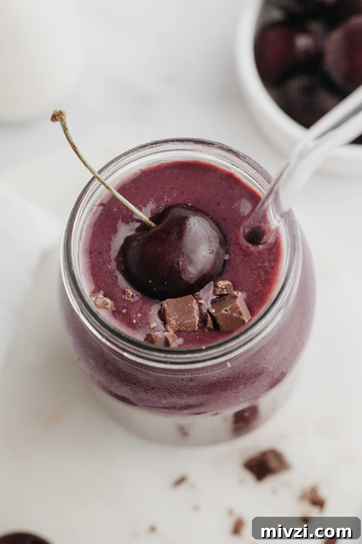 5-Minute Chocolate Cherry Smoothie Recipe 5 A chocolate cherry smoothie in a glass jar, it is topped with a fresh cherry.