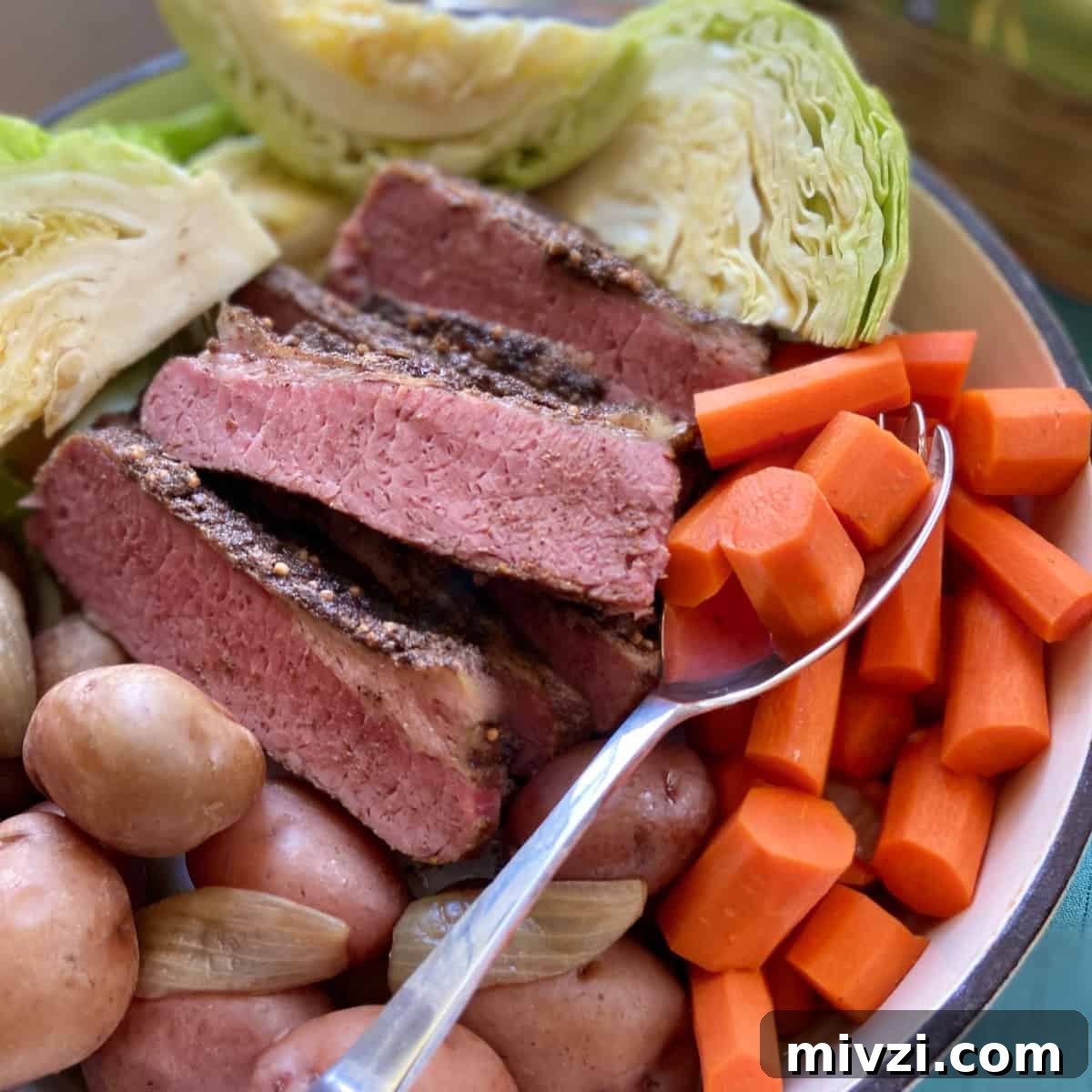 Slow Cooker Corned Beef and Cabbage Recipe for Tender, Juicy Results 4 Corned Beef, cabbage, carrots and potatoes in stockpot with serving spoon.