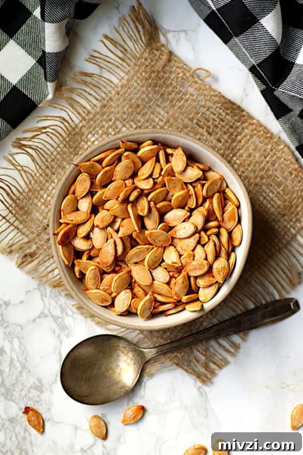 Roasted Pumpkin Seeds Recipe: Crispy Oven-Baked Snack in 20 Minutes 6 Overhead photo of roasted pumpkin seeds in a bowl.