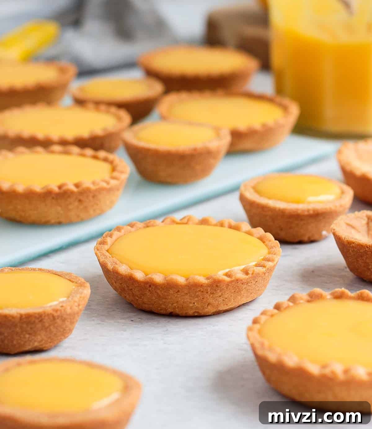 Finished lemon tarts on a grey surface.