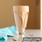 18 Creamy Smoothies Without Banana: Delicious Dairy-Free Recipes 19 Chocolate smoothie spilling over the side of a large tall glass.