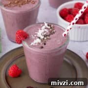 18 Creamy Smoothies Without Banana: Delicious Dairy-Free Recipes 10 Berry smoothie on a dark plate with a heart straw.