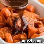 Southern-Style Candied Yams with Brown Sugar Glaze 13 A dish full of yams with a treacle being poured over the top.
