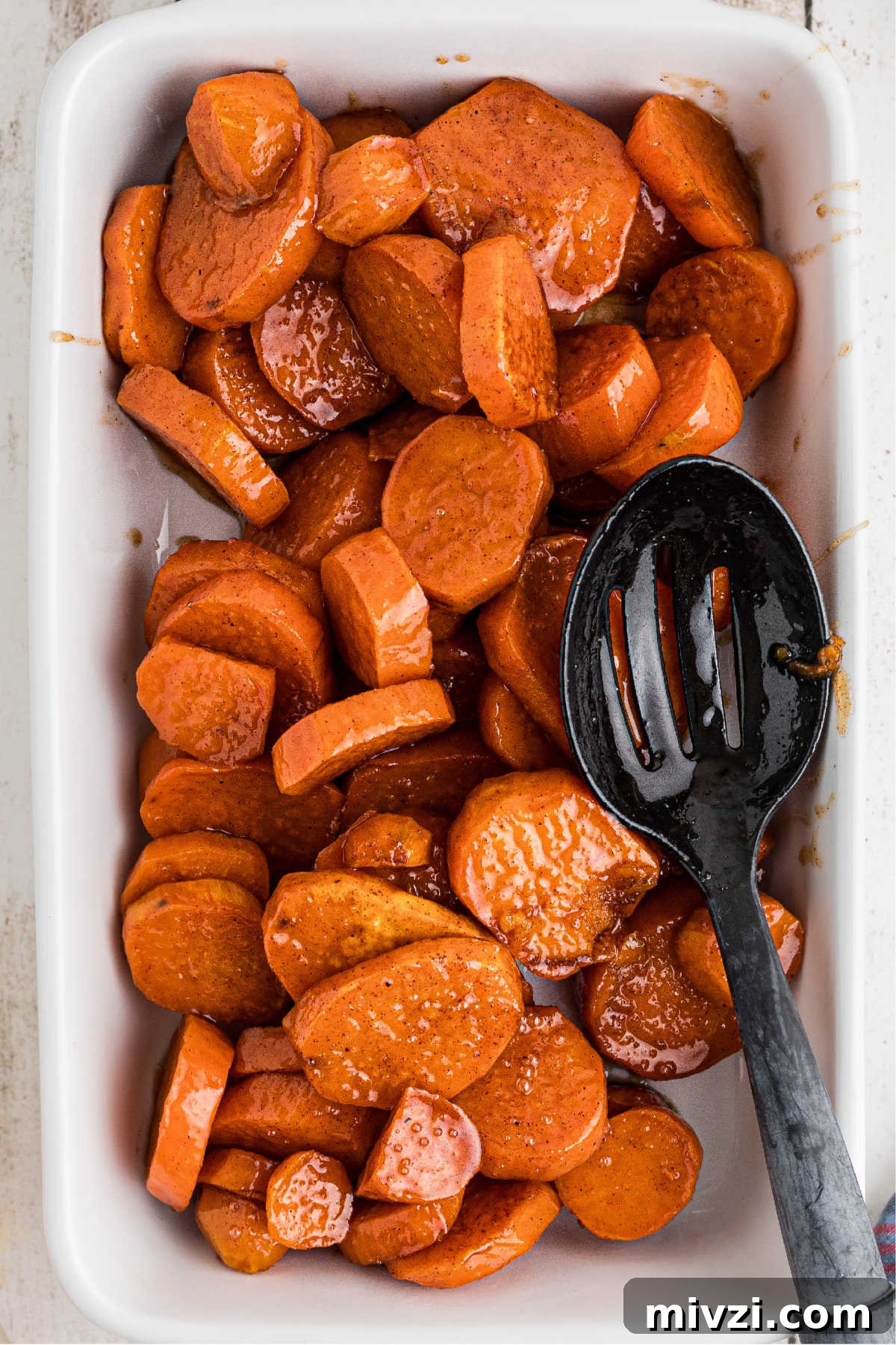 Southern-Style Candied Yams with Brown Sugar Glaze 8 Candied yams added to a serving dish.
