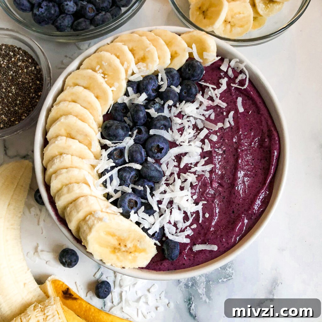 blueberry smoothie bowl with sliced bananas, fresh blueberries, and chia seeds.