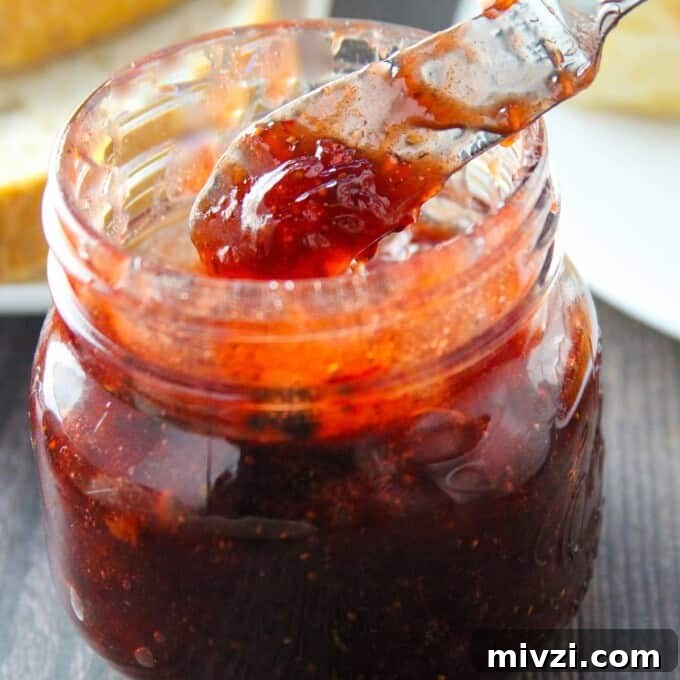Strawberry Jam with Cracked Black Pepper: Sweet & Spicy Preserve 6 Serving Black Pepper Strawberry Jam from mason jar with a spoon