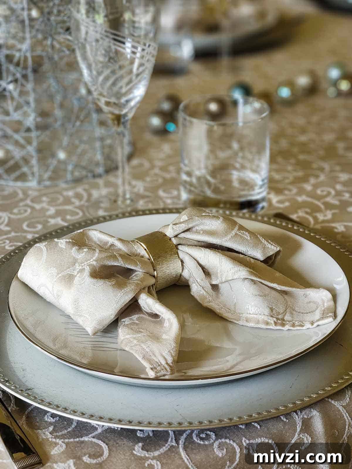 A grey napkin folded into a bow on a place setting.