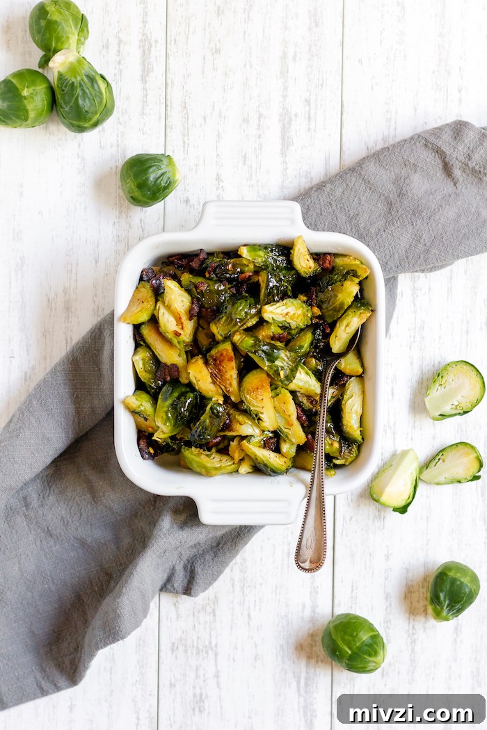 Image shows a pan of roasted brussels sprouts photographed from above on a table