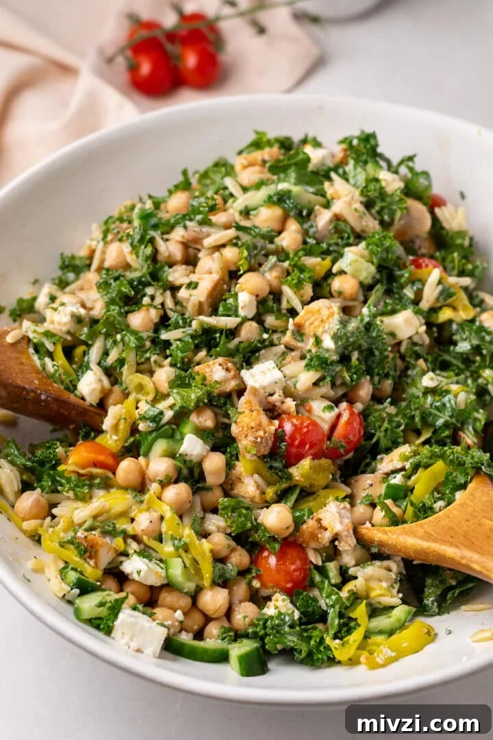 large white bowl with chicken and chickpea salad with tomatoes, kale, pepperoncinis, cucumbers and balsamic dressing