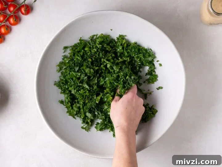 hand massaging kale in a large white bowl