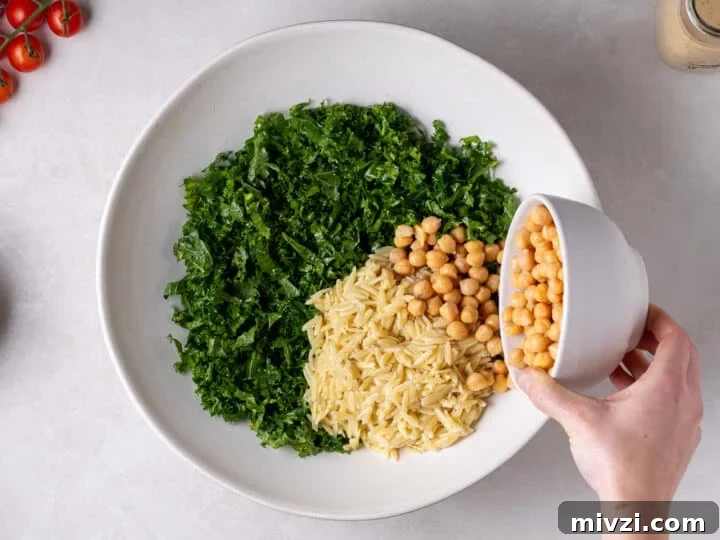 orzo and chickpeas added to the kale in the salad bowl