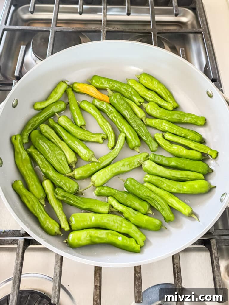 Raw shishito peppers in a pan.