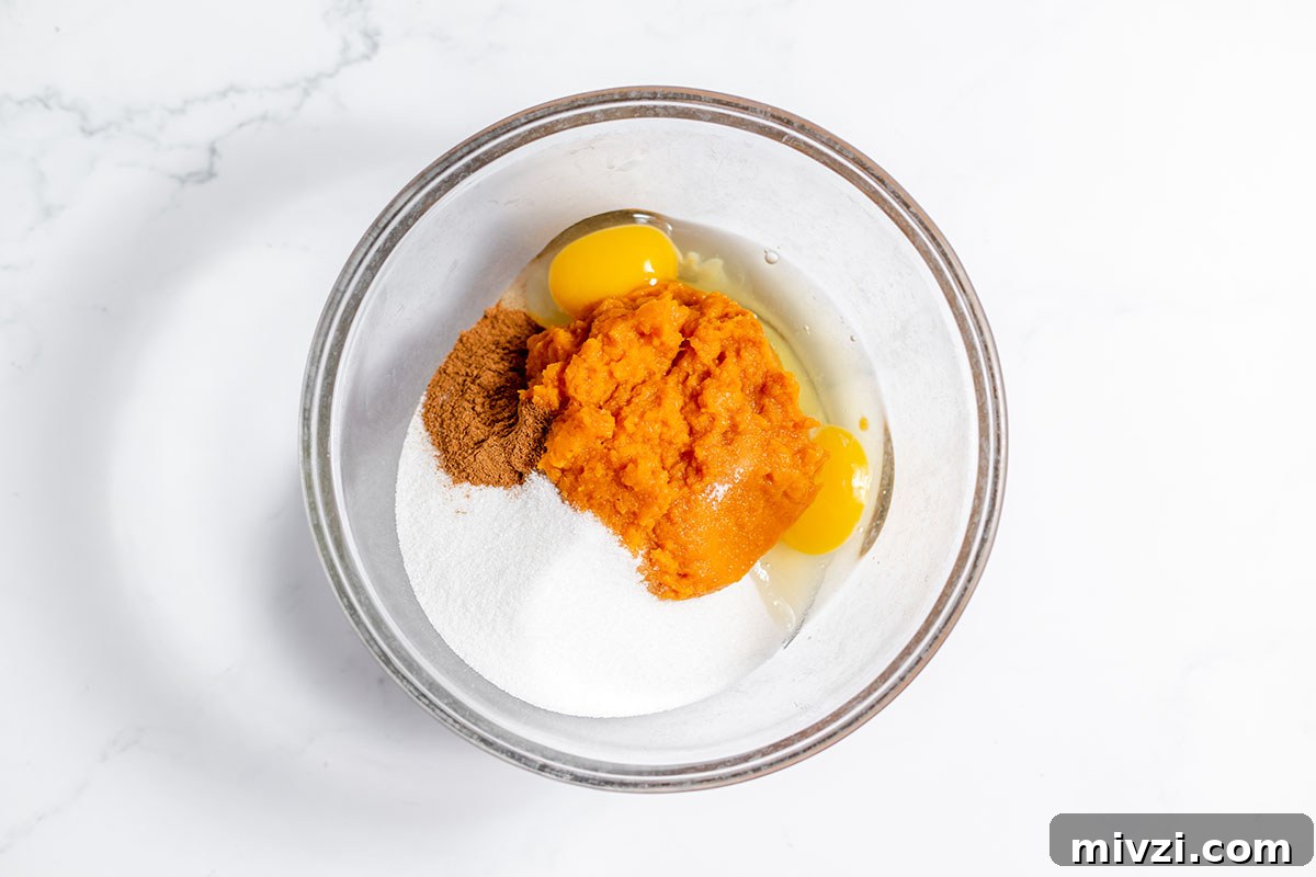Creamy Pumpkin Pie Bars with Gingersnap Crust — Fall Dessert Recipe 6 Pumpkin puree, eggs, spices, and sugar in a large bowl.