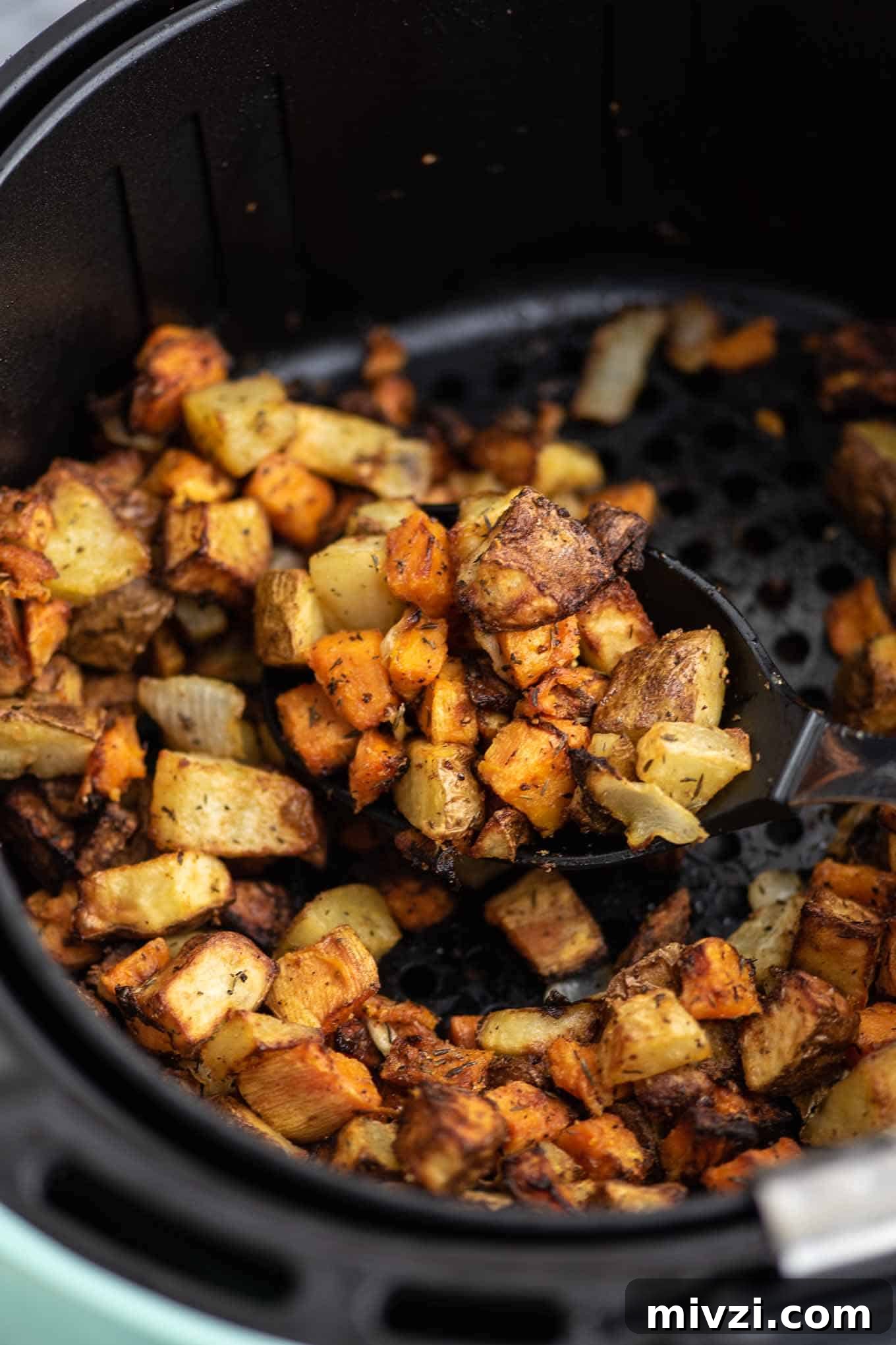 Crispy Air Fryer Breakfast Potatoes Recipe 6 a spoon taking a scoop of the finished potato hash