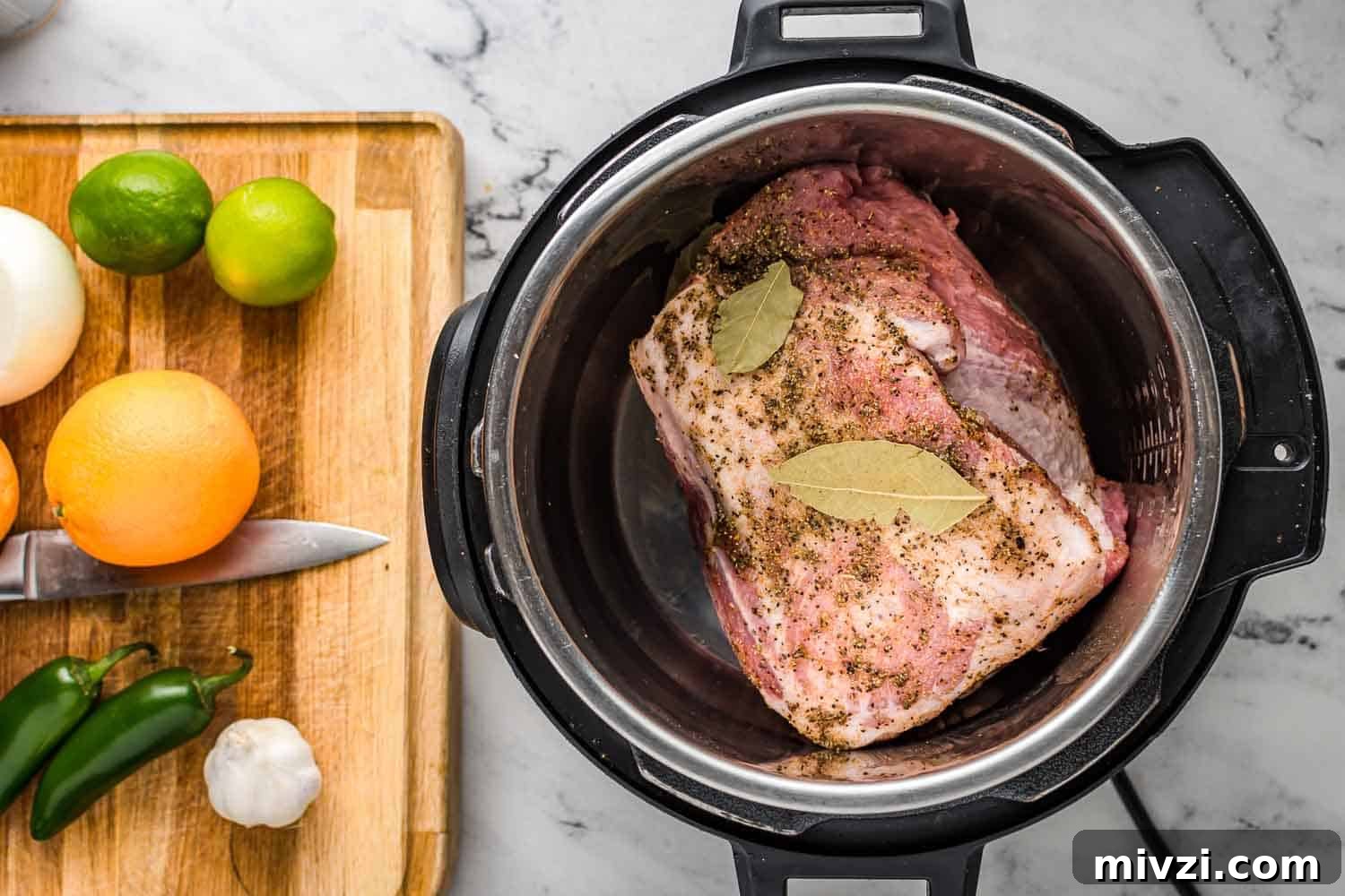 Tender Instant Pot Carnitas Recipe for Quick Mexican Pulled Pork 4 Pork shoulder in the instant pot, and a cutting board with limes, oranges, jalapeños, garlic.