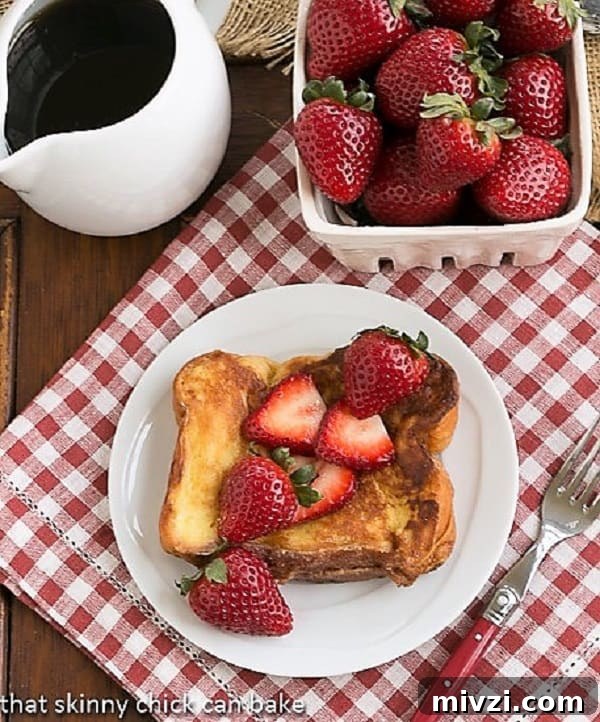 Strawberry Mascarpone Stuffed French Toast - a delicious twist on the classic French toast recipe with a filling of luscious mascarpone and sweet berries! Strawberry Mascarpone Stuffed French Toast overhead view with syrup and a basket of strawberries.