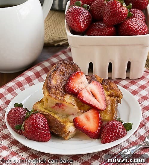 Stuffed French Toast Recipe - An elegant brunch entree filled with rich mascarpone cheese and fresh strawberries. Strawberry Mascarpone Stuffed French Toast cut in half and served topped with sliced strawberries.