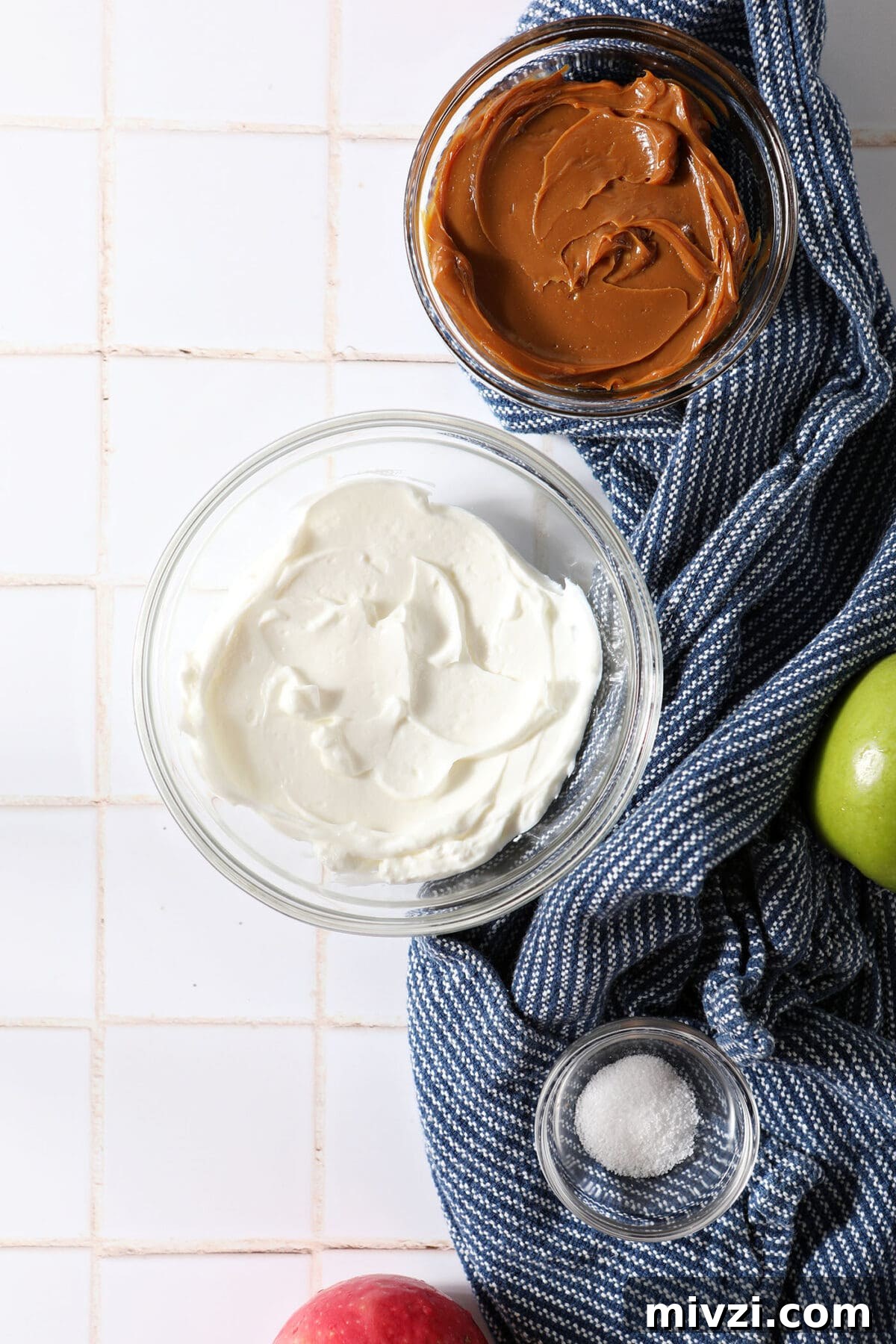 Creamy Dulce de Leche Dip Recipe for Desserts and Snacks 3 Ingredient to make Dulce de Leche Dip in bowls on a white tiled surface with a blue linen