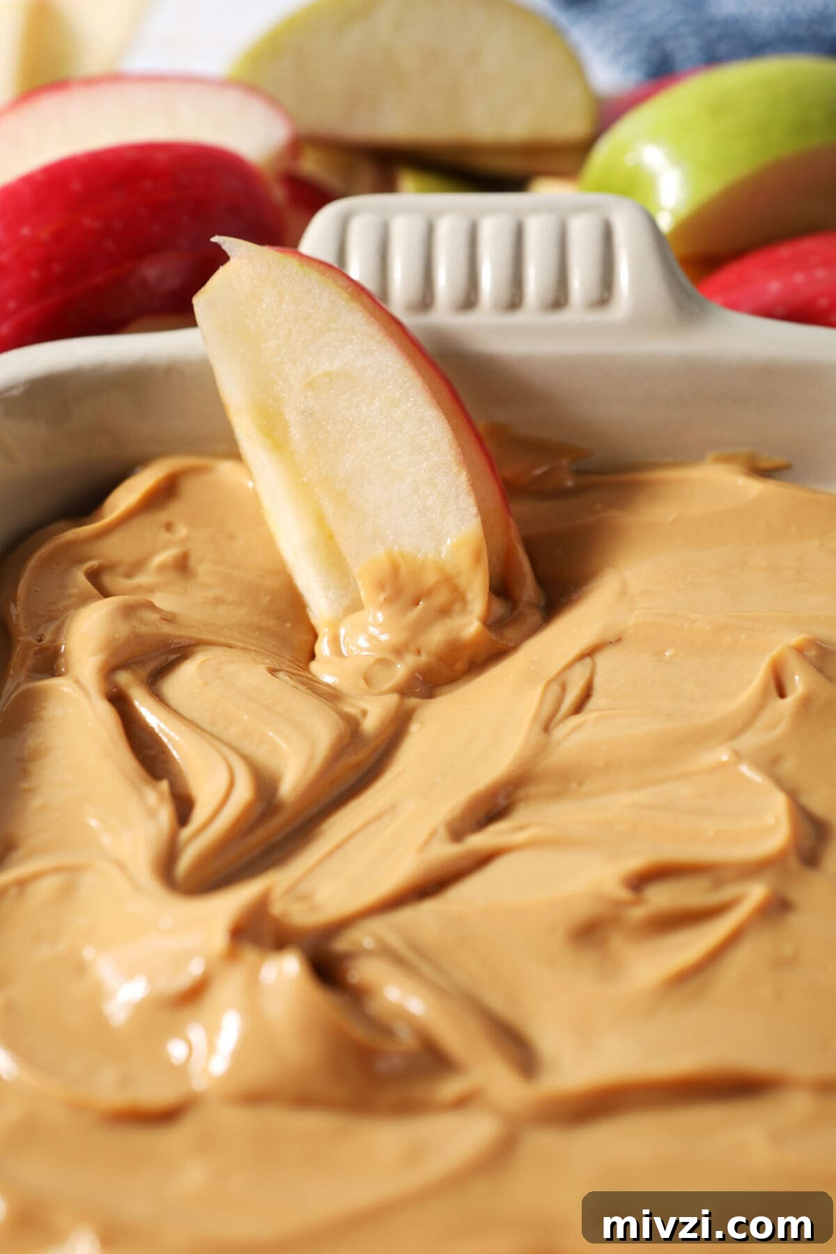 Creamy Dulce de Leche Dip Recipe for Desserts and Snacks 8 Close up of two apple slices sitting in dulce de leche dip