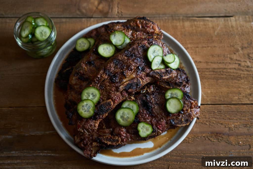 Grilled beef short ribs on a white plate topped with quick pickles.
