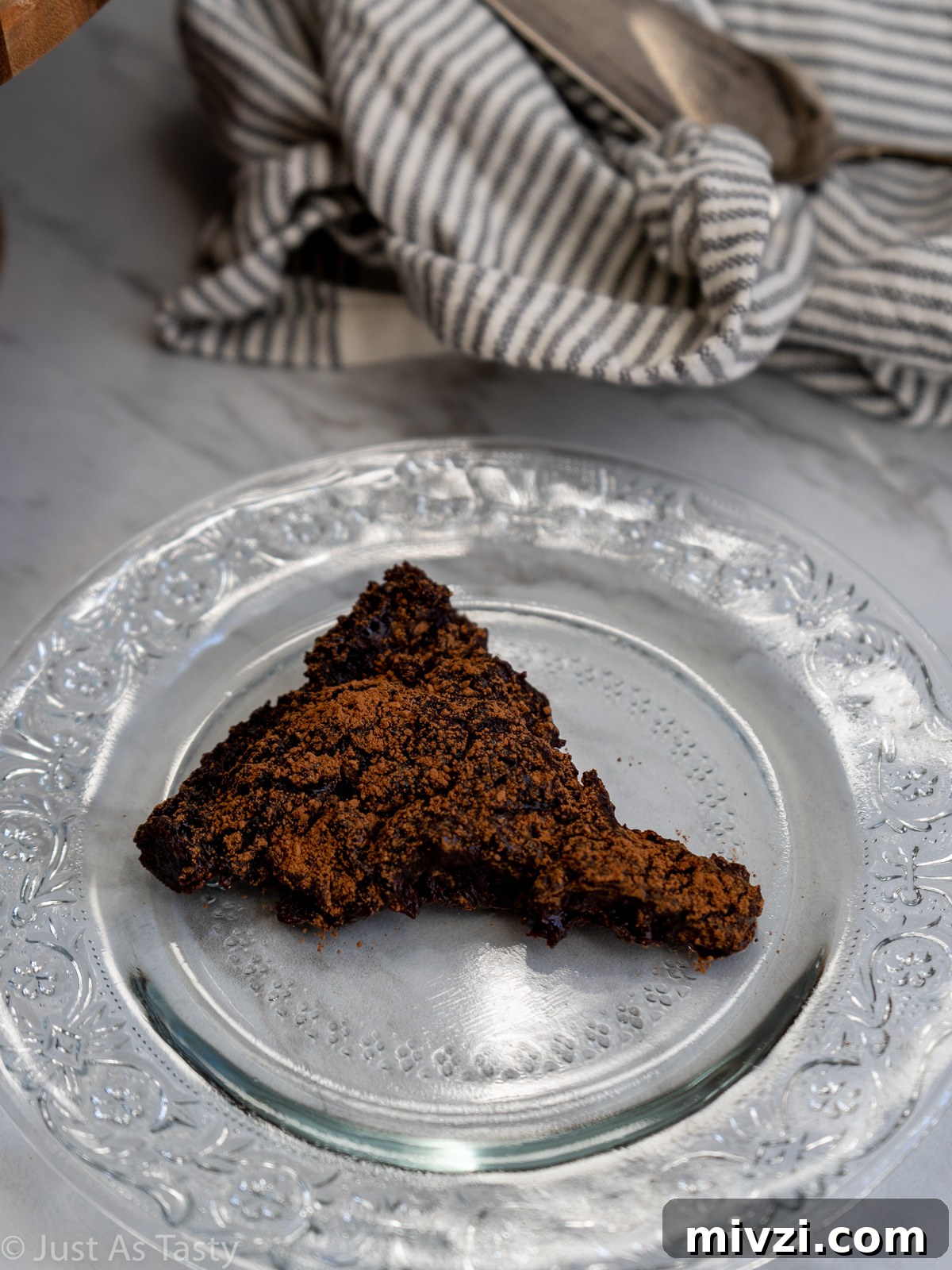 Decadent Flourless Chocolate Cake — Gluten-Free & Eggless 3 Slice of flourless chocolate cake on a glass plate.