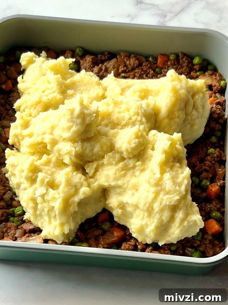 Classic Shepherd's Pie Recipe with Savory Beef and Mashed Potato Topping 8 Meat mixture spread in baking dish and topped with mashed potatoes.