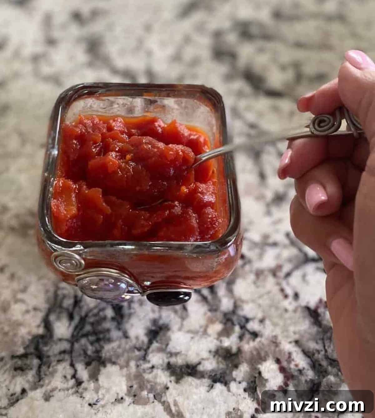 Tomato jam recipe in a bowl with a spoon. 