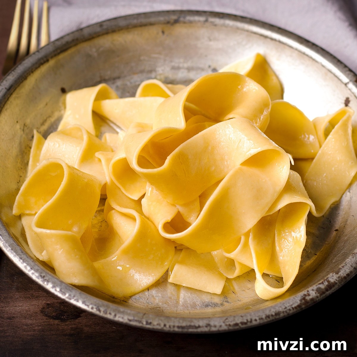 Homemade Pappardelle Recipe: Fresh Pasta from Scratch 21 A tin plate filled with freshly cooked homemade pappardelle noodles.